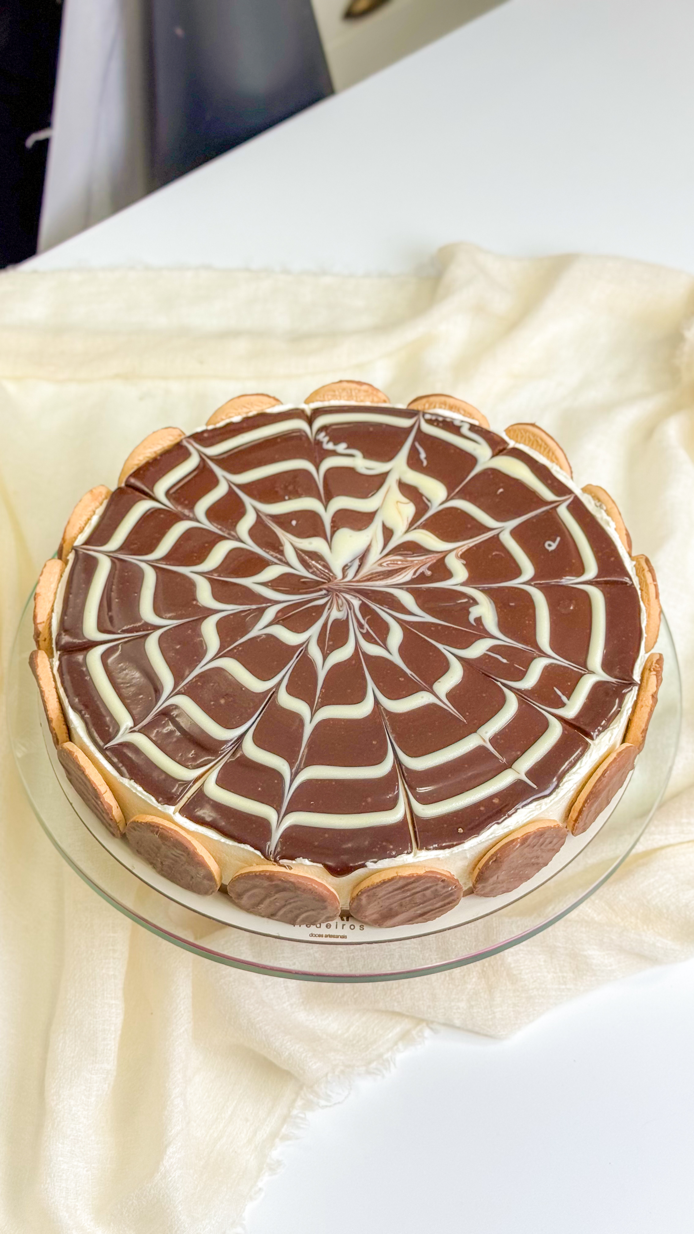 Torta de chocolate com padrão de chocolate branco e biscoitos
